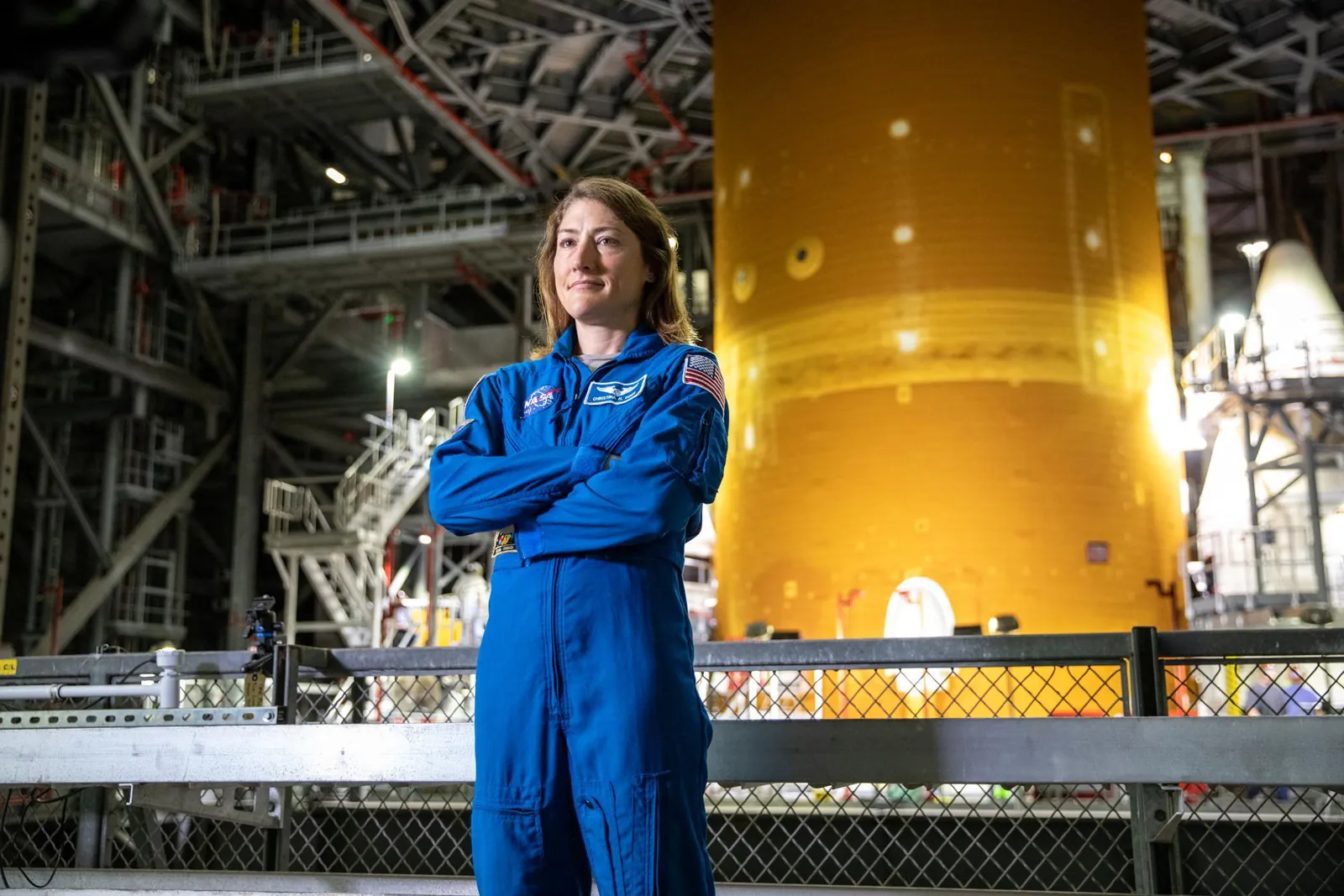 NASA astronaut Christina Koch stands inside Kennedy Space Center’s Vehicle Assembly Building on July 14, 2021, in front of the agency’s Space Launch System (SLS) rocket that ultimately powered the Ori
