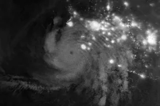 Gravity waves in the upper atmosphere appear as a semicircle of ripples in a nighttime, grayscale satellite image. Hurricane clouds and city lights in Mexico are also visible.