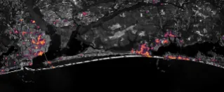 Nighttime lights along the Florida Panhandle coast on October 11, 2026, after Hurricane Isaias, with fewer and dimmer lights in Pensacola and Destin and gaps along the road between them.