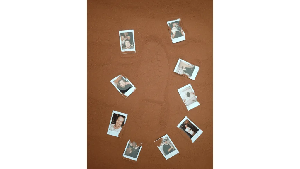 Photos that the CHAPEA Mission 2 crew arranged around a boot print in the simulated Martian sand outside their habitat.