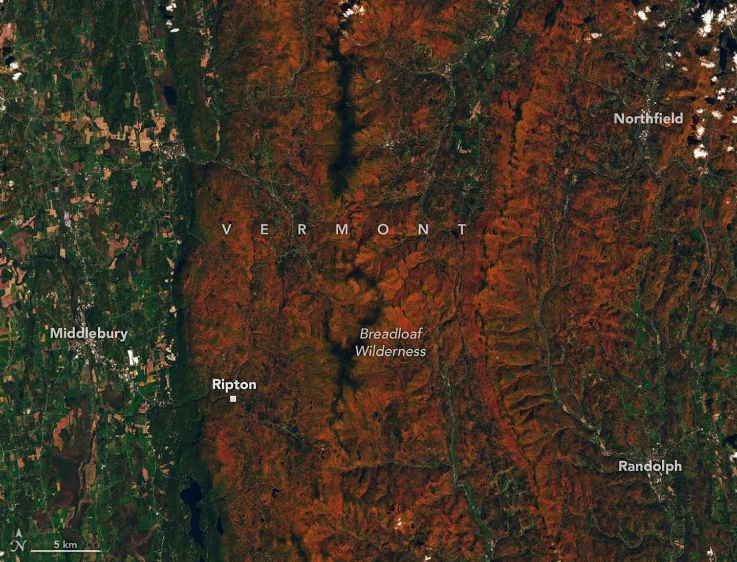 Ridges and mountains in a forested area appear orange, while river valleys and lower-elevation areas are still green.
